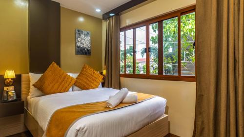 una camera da letto con un letto con due asciugamani sopra di Hollywood Hotel Puerto Princesa a Città di Puerto Princesa