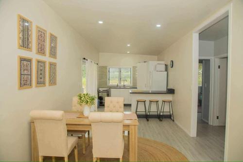 una cucina e una sala da pranzo con tavolo e sedie di 2 Bedroom House - Villa Teremoana a Ngatangiia