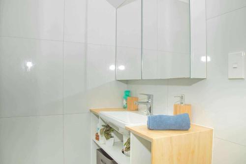 un bagno bianco con lavandino e armadi bianchi di 2 Bedroom House - Villa Teremoana a Ngatangiia