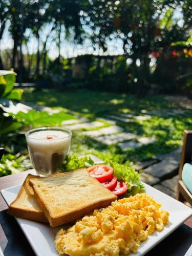 a plate of breakfast food with toast and a drink at Laoxao RiverStone Villa in Hoi An