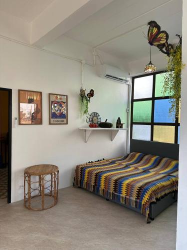a bedroom with a bed and a table and a window at Fluffy Cat Paradise in Ko Bu Bu