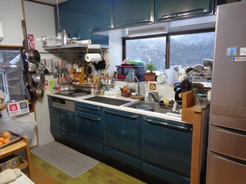 a kitchen with blue cabinets and a sink at Premium Guest House Alaskan Dream in Akiota