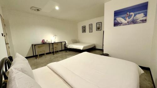 een ziekenhuiskamer met 2 bedden en een bureau bij WAKE UP @Lanta Hotel : Cafe in Koh Lanta