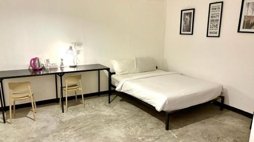 een slaapkamer met een bed en een bureau met 2 stoelen bij WAKE UP @Lanta Hotel : Cafe in Koh Lanta