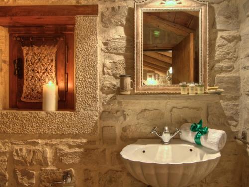 a stone bathroom with a sink and a mirror at Villa Anastasia in Prinés