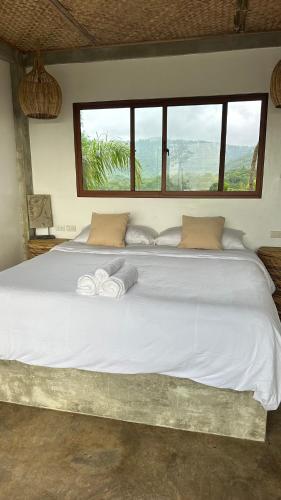 a large white bed with two towels on it at VISTA Cadlao in El Nido Airport