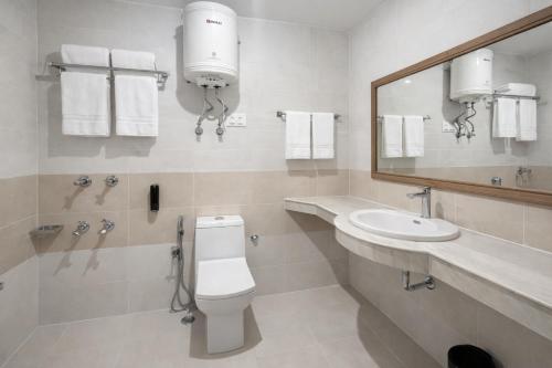ein Badezimmer mit Toilette, Waschbecken und Spiegel in der Unterkunft Hotel Hollywood Vibes #riverview #premium rooms #prime location #most awarded #parking #top rated #open terrace #lawn #best selling hotel in manali in Manali