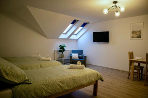 a room with two beds and a tv on the wall at Ízisz Apartman in Mátraterenye