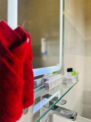 a red sweater is sitting on a bathroom sink at New Aqua Glory in Negombo