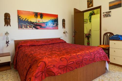 a bedroom with a bed with a red bedspread at Agriturismo Artisti Del Cavallo in Foiano della Chiana