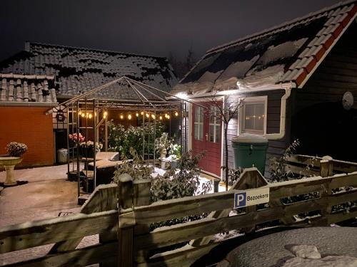 a house with christmas lights on the front of it at Bed en Brochje De Oase in Sweagerbosk