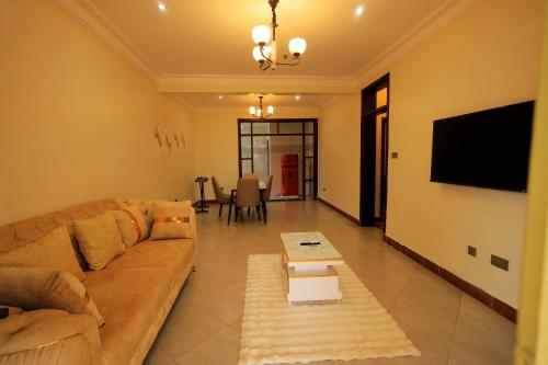 ein Wohnzimmer mit Sofa und Flachbildfernseher in der Unterkunft Homes by her in Entebbe