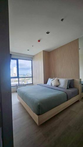 a bedroom with a large bed with a large window at Kuno - 2Br, Beachfront Jomtien in Jomtien Beach