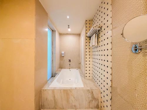 a bathroom with a large bath tub with a window at Spree Hotel Meerut in Meerut