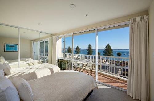 ein Schlafzimmer mit zwei Betten und einem großen Fenster in der Unterkunft Beaumont Apartments in Mount Maunganui