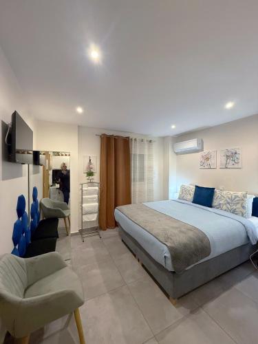 a bedroom with a king sized bed and a chair at Aloha Inn in Artemida