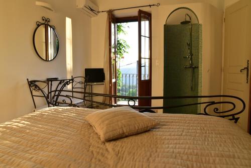 a bedroom with a bed with a mirror and a shower at Aux Bords du Temps in Zonza