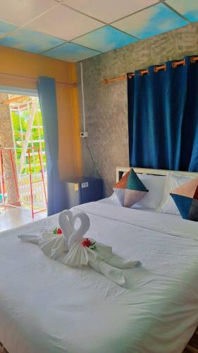 a white bed with a dress on top of it at Mook Phoopha Guest House in Ko Mook