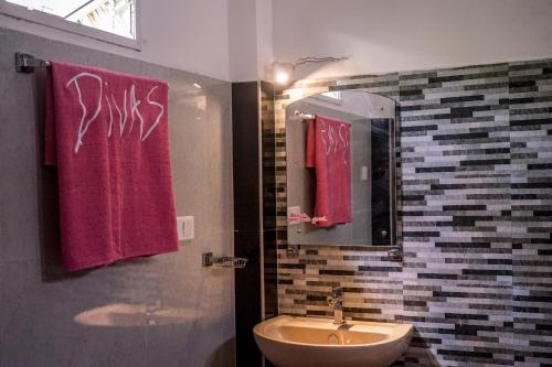 a bathroom with two red towels and a sink at Divas Hostels in Ahangama
