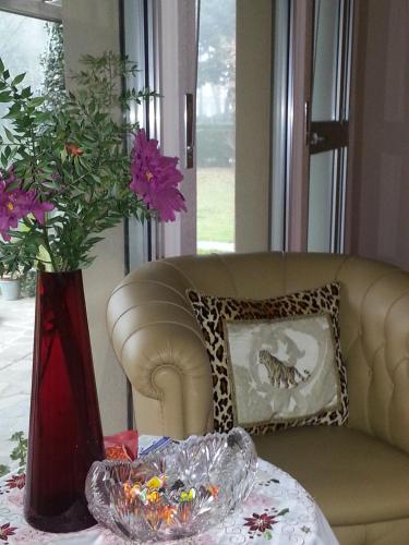 a vase with flowers on a table next to a couch at Al Villino del Sole in Fano