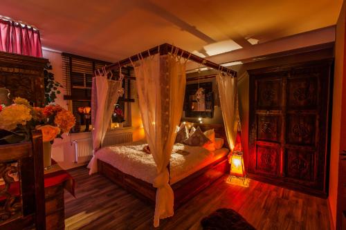 - une chambre avec un lit à baldaquin et des rideaux dans l'établissement Whirlpool Suite Marrakesch-Lounge, à Stelle