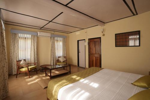 a bedroom with a bed and a living room at Ri Sai Cottage Stays in Nongpoh