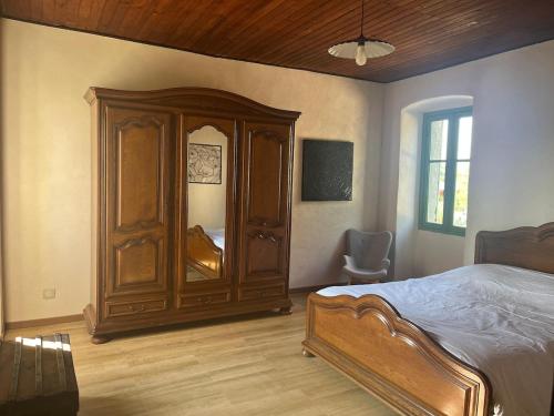 a bedroom with a wooden cabinet and a bed at Casetta Teppe rosse in Aléria