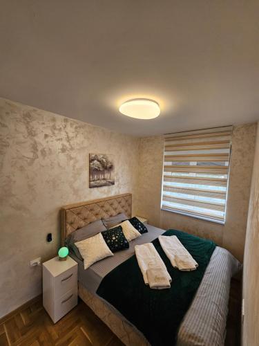 a bedroom with a bed with two pillows on it at Daluxst apartman in Vrnjačka Banja