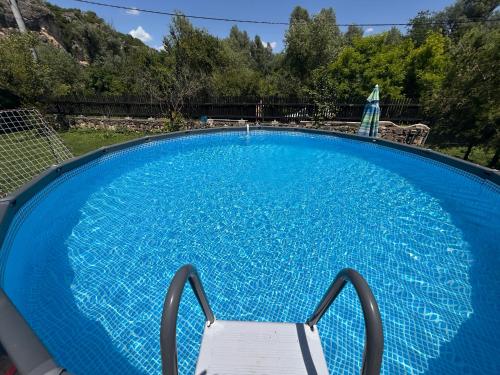 a chair sitting in a large blue swimming pool at Milkovata Guest House in Koshov