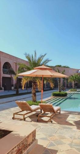 two chairs and an umbrella next to a pool at Sukoon Gah in Bedla