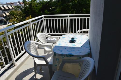 a table and chairs on a balcony with a table and a drink at Galanis Studios and Apartments in Platamonas