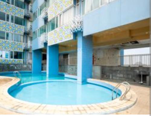a large swimming pool in a large building at Saladin Guest House in Parungmalela