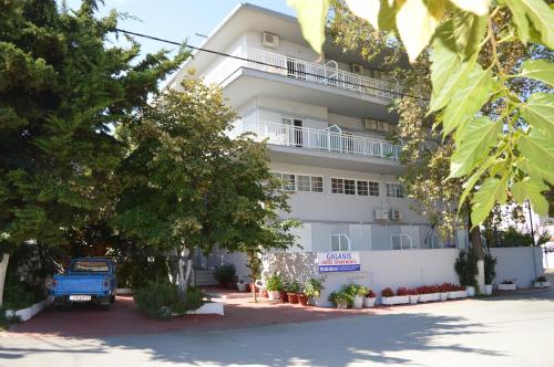 a building with a blue truck parked in front of it at Galanis Studios and Apartments in Platamonas