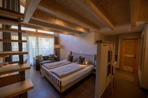 een slaapkamer met een bed en een bank erin bij Alpenlodge in Zermatt
