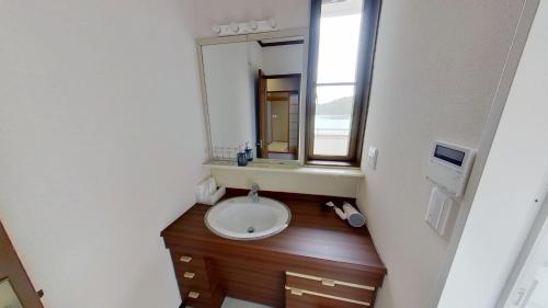 un bagno con lavandino e specchio di H,U,B Unzen - Vacation STAY 01672v a Unzen