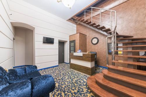 a living room with a staircase and blue chairs at Apart Hotel Kvartira 1 in Odesa