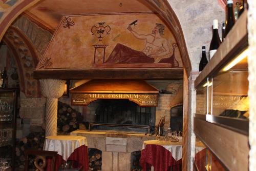 a large fireplace in a restaurant with a painting on the wall at Villa Cosilinum in Padula