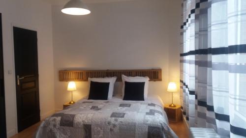 a bedroom with a large bed with two lamps at Apt 5 du Temple HyperCentre & Parking in Cambrai
