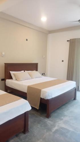 a bedroom with two beds in a room at Opara Palace in Weligama