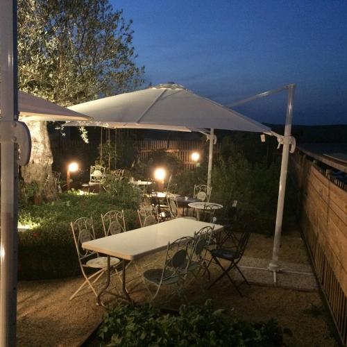 a patio with tables and chairs under an umbrella at Agriturismo Le Spighe in San Donato