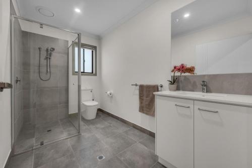 a bathroom with a shower and a sink and a toilet at IK homes in Clyde North