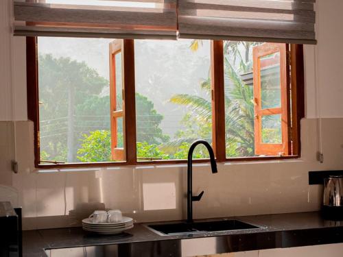 a kitchen with a sink and a window above a counter at Ceylon Vista in Galle