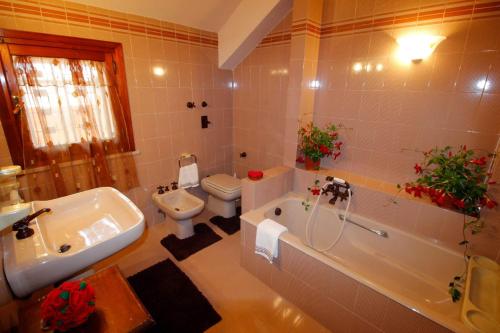 a bathroom with a tub and a toilet and a sink at B&b Villa Rosella in Petrosino