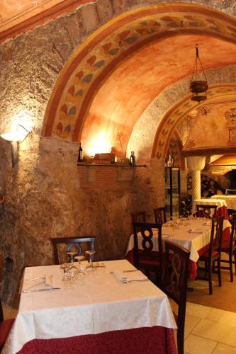 a dining room with two tables and a stone wall at Villa Cosilinum in Padula