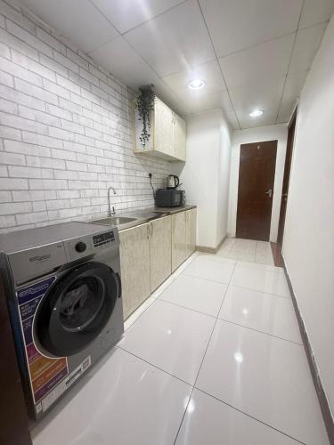 a kitchen with a washing machine in a room at Grand Stay Abu Dhabi in Abu Dhabi