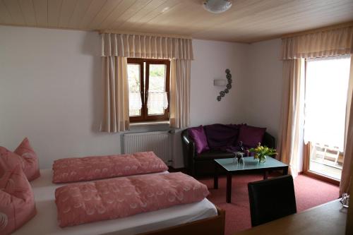 a bedroom with a bed and a couch and a table at Alpenchalet Bianca in Ramsau