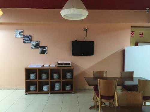 comedor con mesa y TV en la pared en Hotel Jonquera, en La Jonquera