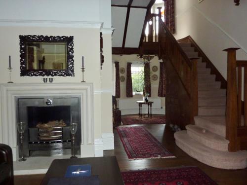 a living room with a staircase and a fireplace at The Manse B&B in Eastbourne