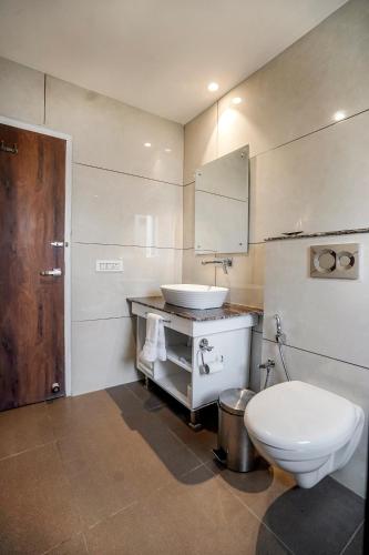 a bathroom with a white toilet and a sink at The Retreat Mashobra, Shimla in Shimla