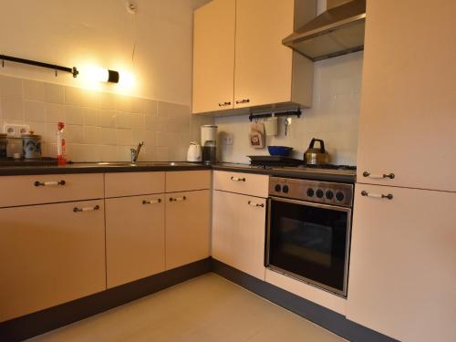 a kitchen with white cabinets and a stove top oven at Holiday home in a quiet, authentic mountain village with a view of the surrounding hills in Zlatá Olešnice